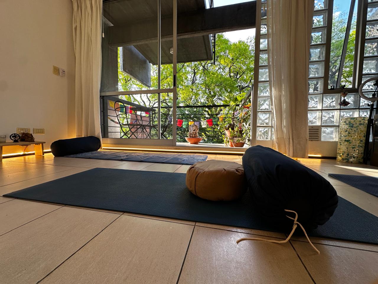 Sala principal de Cauce Yoga en Villa Devoto, preparada con mats y almohadones
